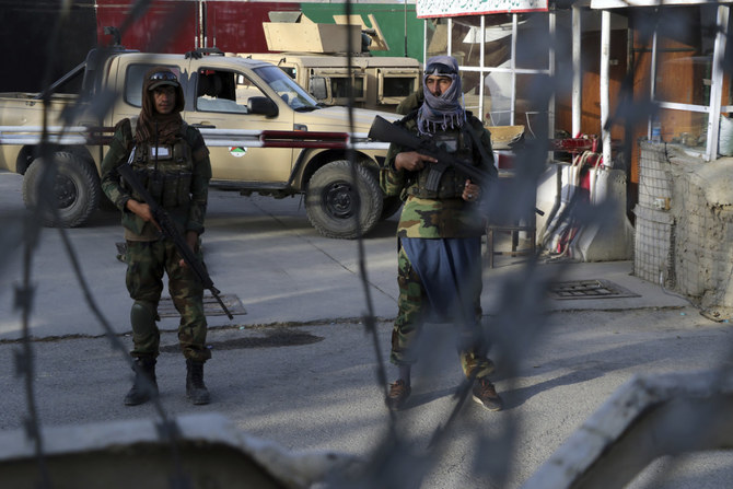 2021年8月28日、出国を希望するアフガニスタン人がカブール空港の正面ゲートを通過する際に、「特殊部隊」であるタリバンの「バドリ」部隊の戦闘員が見張りをしている。(AFP)
