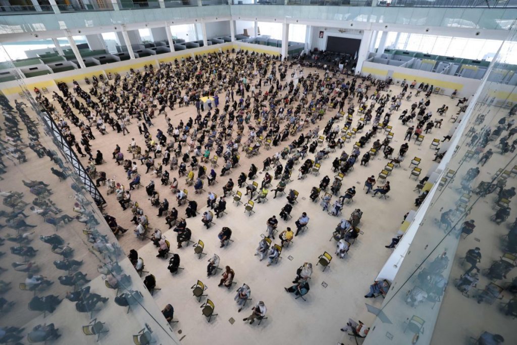 2021年8月14日、テヘランのイラン・モール内に設置されたCOVID-19ワクチン接種センターで男性に接種を行うイランの医療従事者。（写真：Atta Kenare/AFP通信）