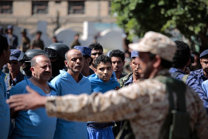 2021年9月18日（土）、イエメン・サヌアのタハリール広場で行われる処刑を前に、フーシ派幹部サレハ・アル・サマド氏の殺害に関与したとして有罪判決を受けた男性たちの横で見張りをする警察隊員ら。（AP通信）