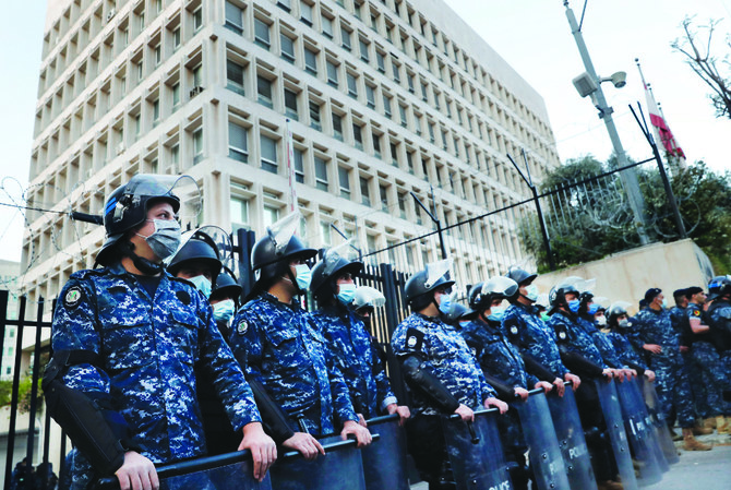 ベイルートの中央銀行のビル前の警備に立つレバノン警察官。悪化する財政危機に対し、反政府デモの参加者が抗議を行っている。(AP資料)