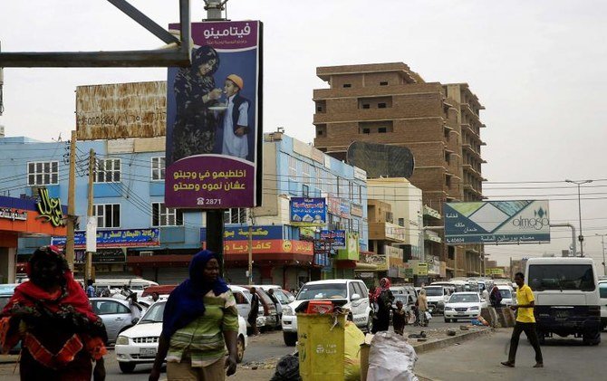 スーダンのハルツームの通りに沿って往来するスーダンの人々と交通の様子を示す全景。（ロイター通信）