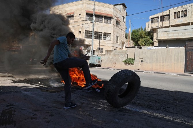 （上）2021年9月26日、イスラエルの占領下にあるヨルダン川西岸地区の都市ジェニン西部で、タイヤを燃やすパレスチナ人のデモの参加者 (AFP)