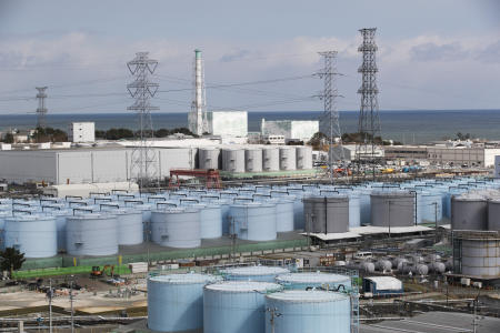 2021年2月27日（土）、福島県大熊町にある福島第一原子力発電所の5号機（中央左）と6号機（右）の前に並べられた、微量の放射能が残った処理水の貯蔵タンク。（AP通信）