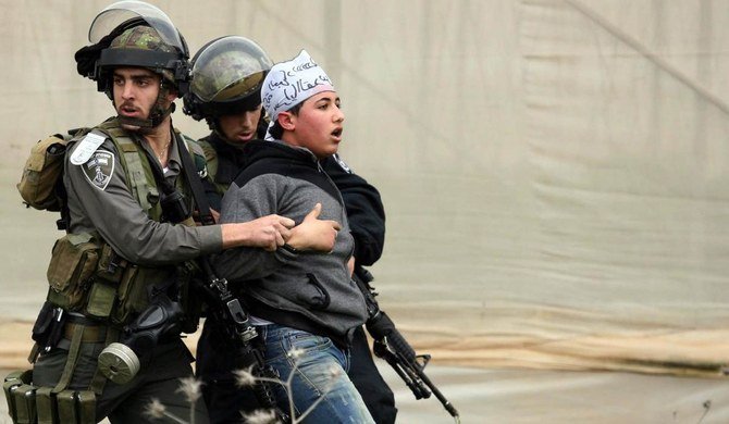 ヨルダン川西岸地区のジェニン近郊にあるジャラマ検問所の入り口での衝突の最中、パレスチナ人デモ参加者を拘束するイスラエル国境警察。(File/AFP)