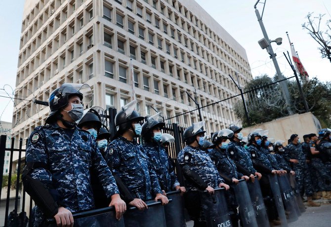 ベイルートにて、反政府デモがレバノン中央銀行頭取リアド・サレメー氏と深刻化する金融危機に対して抗議活動を行う中央銀行前をレバノン機動隊が警護する。 (AP)