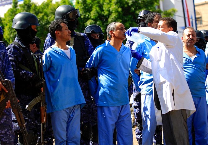 3年前のフーシ派政治指導者サーレハ・アル・サマド氏の暗殺に関与したかどで他の8人と共に有罪判決を受け、処刑前の被告に水を与える衛生兵。（AFP）