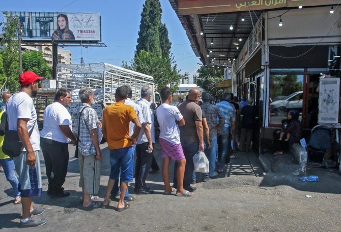 8月13日、南部の沿岸都市シドンのパン屋の前でパンを買うために並ぶレバノン人の列。レバノンでは経済危機の深刻化に伴い、さまざまな生活必需品が不足している。（ファイル写真： AFP） 
