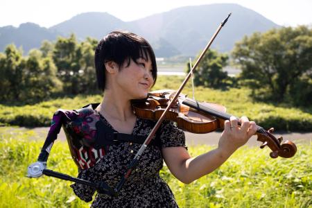 写真は2021年8月28日、静岡での撮影会で、義手を使ってバイオリンを演奏する日本の音楽家、伊藤 真波さん。（AFP通信）