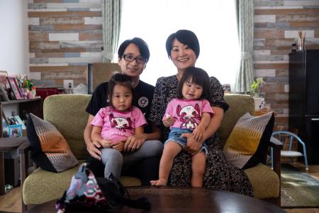 2021年8月28日、静岡の自宅で、夫のユキさん、2人の娘のミウちゃん（左）とメイちゃんと一緒にポーズをとる日本のバイオリニスト、伊藤 真波さん（右上）の写真。（AFP通信）