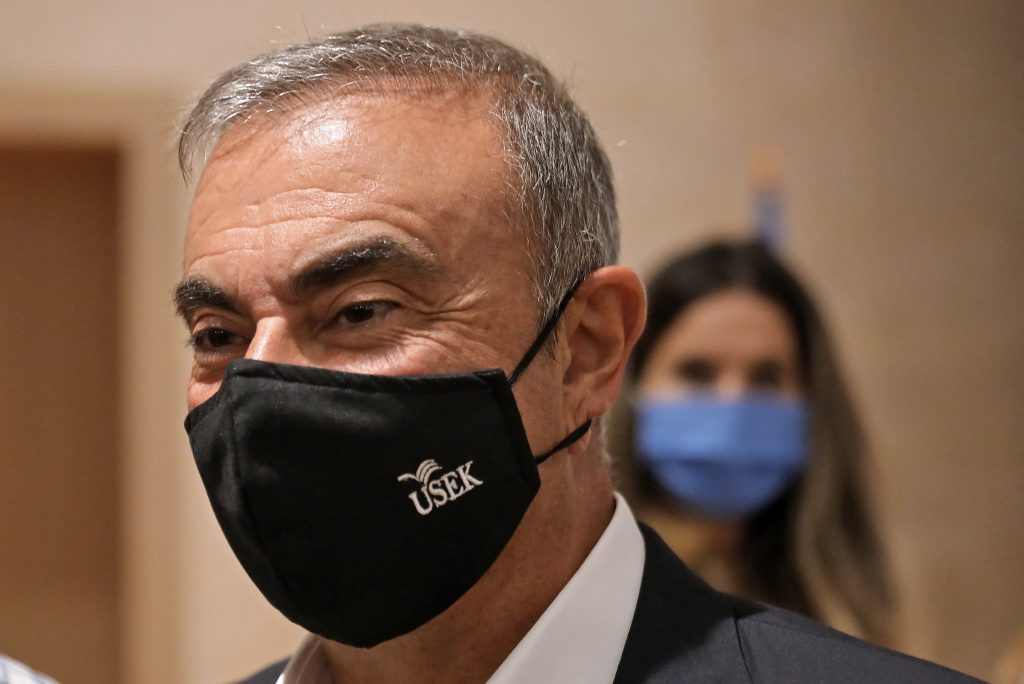 2020年9月29日、日産自動車のカルロス・ゴーン元会長はCOVID-19のパンデミックの中、防護マスクを着用し、レバノン北部の都市ジュニーエで、危機に瀕した国の支援を目的としたカスリク大学（USEK）との共同イニシアチブ立ち上げの記者会見の後、記者たちに語りかけている。（AFP通信）