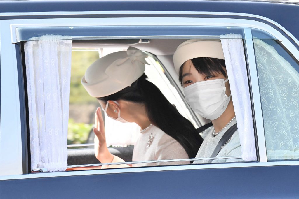 雨の降る中、しっかりとした足取りでそれぞれの陵の前に進み、玉串をささげて拝礼した。(AFP)