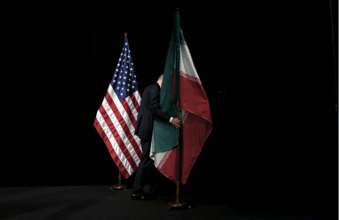 2015年7月14日、ウィーンでのイラン核協議で、各国の閣僚や代表との集合写真を撮った後、ステージからイランの国旗を取り除く職員。（ロイター通信）