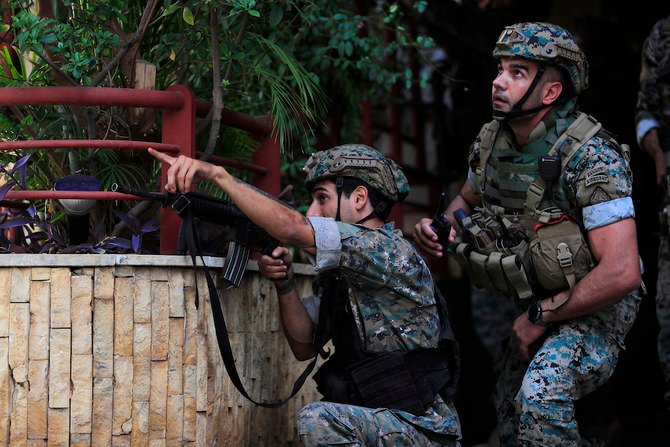 2021年10月14日、ベイルートの抗議活動中、銃撃に対応するレバノン治安部隊。（AP）