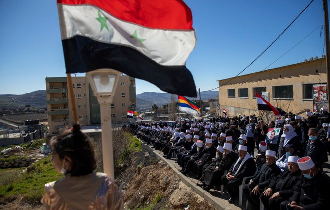 シリア国境付近でゴラン高原の返還を要求する集会中にシリア国旗を振る、シリアのバッシャール・アル・アサド大統領を支持するドゥルーズ支援者。1967年にイスラエルによって占領された、ゴラン高原のマジャルシャムスで。（AP/ファイル）
