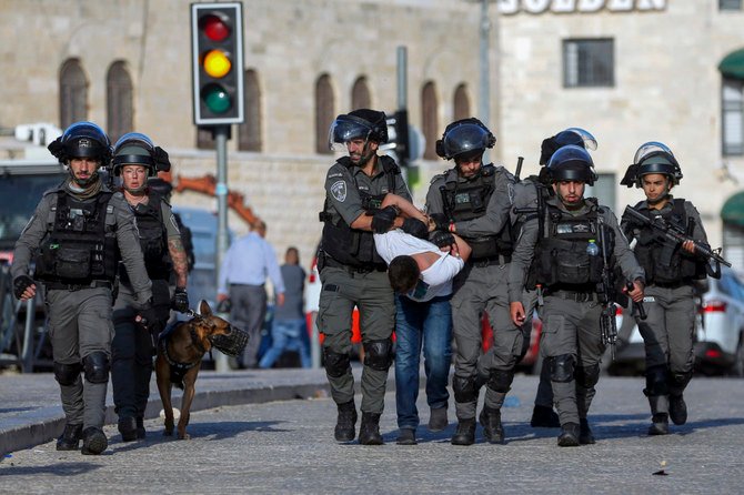 2021年10月19日、エルサレムの旧市街に数千人のイスラム教徒が押し寄せた際の衝突で、パレスチナ人の若者を拘束するイスラエルの国境警察官。（AP写真）