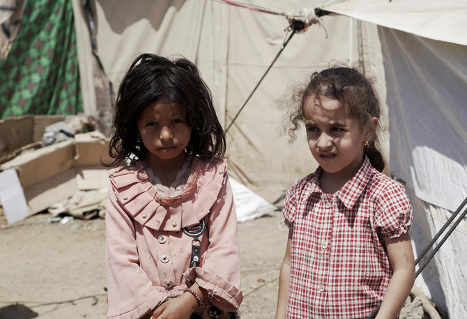 イエメン、マアリブ郊外にある国内避難民キャンプのテントの前に立つ少女たち。2021年10月16日（ロイター）