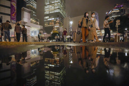 水曜日、東京の繁華街で有名な渋谷のスクランブル交差点を保護マスクを着用した人々が歩く。 （AP）