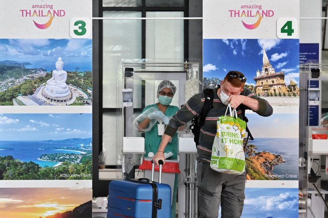 2021年7月1日、タイのプーケット国際空港に到着した際、医療従事者からCOVID-19の綿棒検査を受けた後に反応する国際線乗客。（AFP）