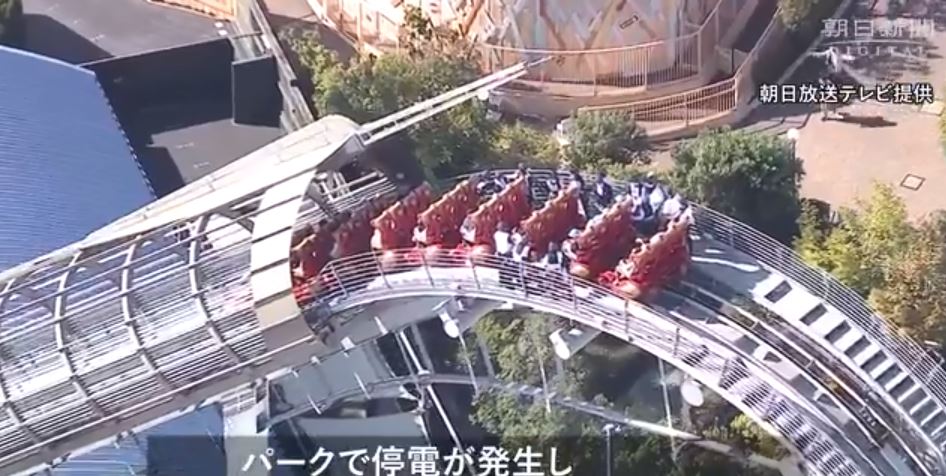 レール上に取り残された乗客はヘルメットをかぶり係員の誘導で全員地上に降りた。けがをした人はいなかった。(スクリーンショット/朝日新聞)