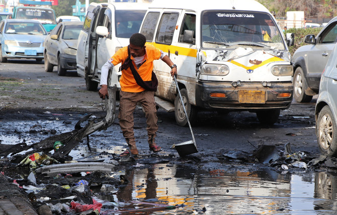 31日、アデンの治安検問所近くにある自動車爆弾攻撃が起きた現場で瓦礫を片付ける作業員。（AP通信）