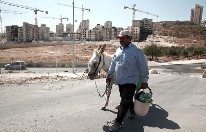 東エルサレムのハルホマ地区にある新しいイスラエルの住宅建設現場近くを歩くパレスチナ人男性。2016年9月撮影。（AP Photo）