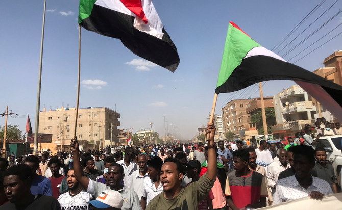 抗議活動への参加者らが旗を持ちスローガンを連呼しつつ、先日のスーダン軍部による政権掌握に抗議するデモ行進を行う。ハルツームにて。（資料/ロイター）