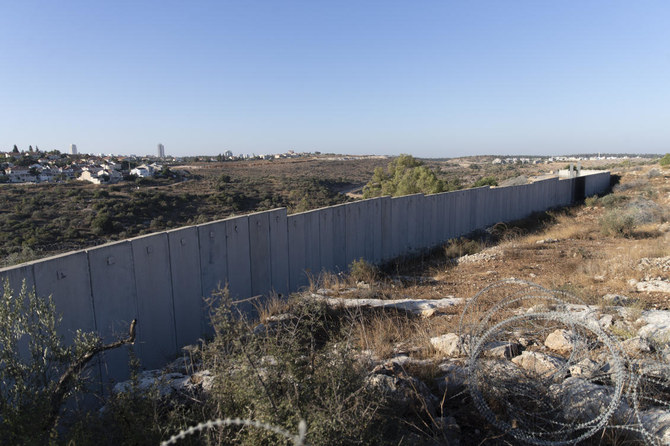 ラマッラーの西に位置するヨルダン川西岸のニリン村にて、イスラエルの分離壁の一部の後ろに見えるイスラエルの入植地ハシュモナイム。2021年11月7日（日）撮影。（AP）
