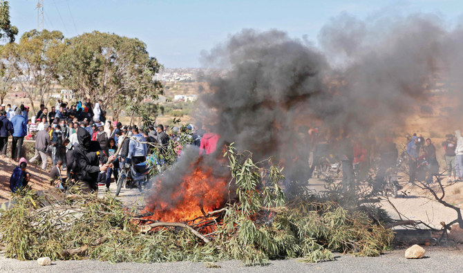 ゴミ集積場の再オープンへのデモ中に起こった参加者の死亡に続き、アガレブ市の道を塞ぐ前に集まるチュニジア人