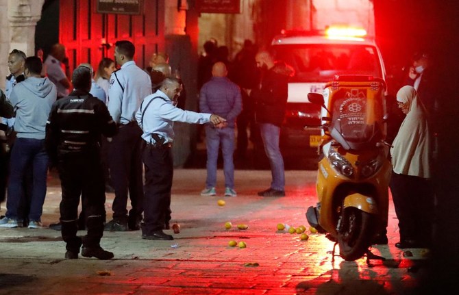 エルサレムの旧市街で起きたとされる刺傷事件の現場に集まるイスラエルの警備隊とその横を走行する救急車。（AFP）