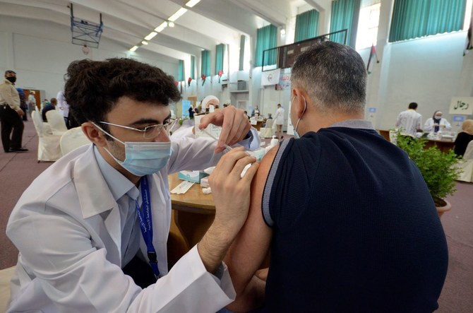 ヨルダンのアンマンで新型コロナワクチンを男性に接種する医療従事者 (File/Reuters)