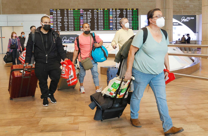 2021年11月1日に撮影されたこの資料写真では、イスラエルが新型コロナのワクチンを接種した観光客の受け入れを再開する中、ロード近郊のベングリオン空港に到着した乗客らが荷物を持って歩いている。（AFP通信）