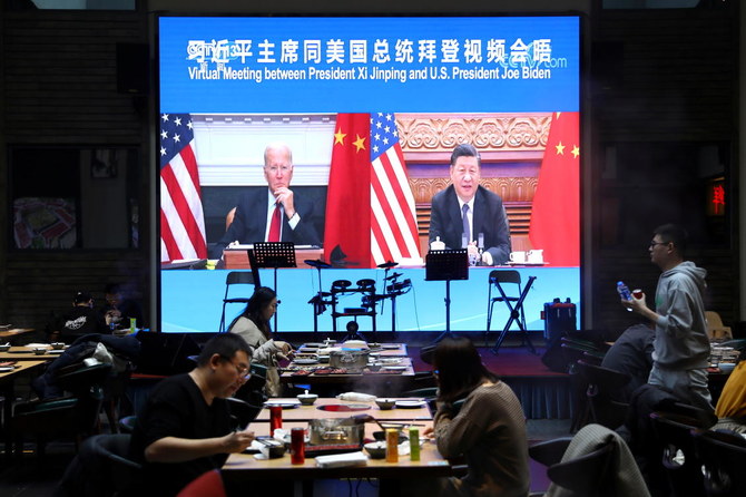 16日、テレビ会議システムを使い、米国のジョー・バイデン大統領とのバーチャル会議に出席する中国の習近平国家主席を映す画面。（ロイター通信）