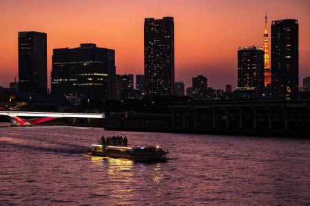 2021年11月20日、東京の背景に東京タワーが見える隅田川を遊覧船が航行します。（AFP）