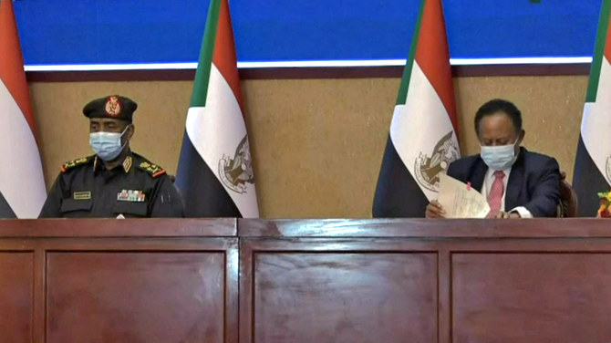 2021年11月21日にスーダンの民政移管プロセスを回復させるための合意に署名する軍トップのアブドゥルファッターフ・ブルハン将軍 (左) とアブダッラー・ハムドゥーク首相 (右) 。 (AFP)