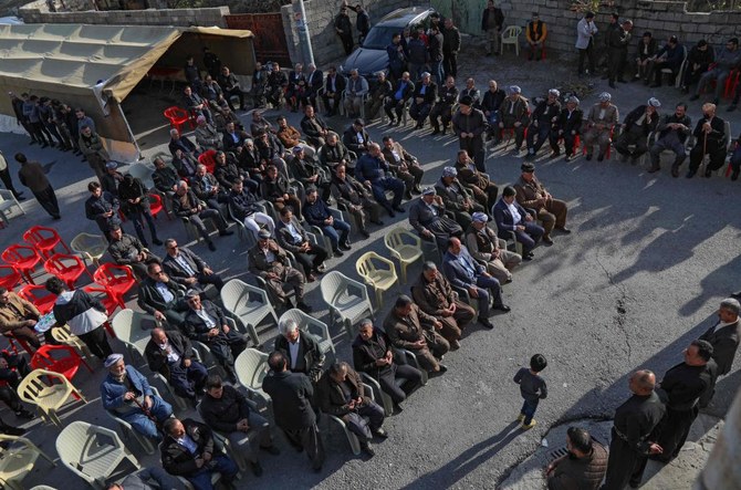 イラクのクルド人移民マリヤム・ヌリ・ハマ・アミン氏の追悼式に出席する男性たち。彼女はヨーロッパに不法入国しようとして亡くなった。2021年11月27日、クルド人の町ソランで撮影。（AFP）