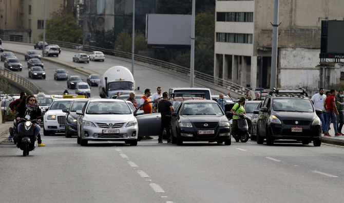 火曜日、ベイルートの物価上昇に抗議し、自分の車で幹線道路を封鎖するタクシー運転手。（AP）