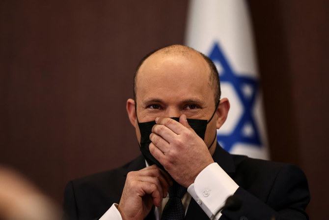 2021年11月28日、エルサレムの首相官邸で行われた閣議で、マスクを調整するイスラエルのナフタリ・ベネット首相。（ロイター通信）