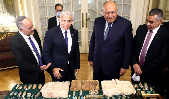 木曜日、カイロのタリール宮殿にて、イスラエルのヤイール・ラピード外務大臣から、エジプトから盗み出された後イスラエルで押収された歴史的遺物の返還を受けるエジプトのサーメハ・シュクリ外務大臣。(ロイター)