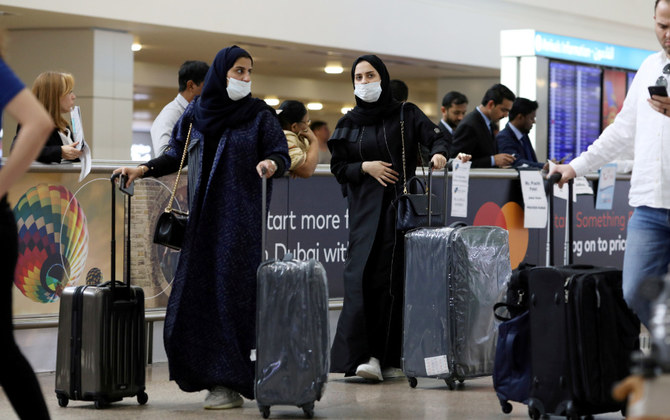 アラブ首長国連邦のドバイ国際空港に到着するマスクを着用した旅行者。(ロイター通信　ファイル写真)