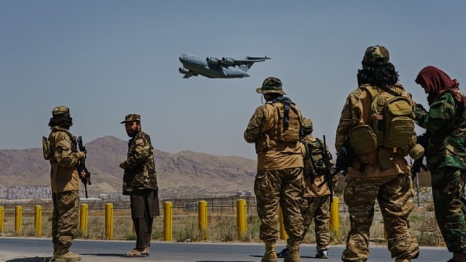 2021年8月29日、アフガニスタンのカブールにあるハミード・カルザイ国際空港の外周をタリバン戦闘員が警備する中、離陸するC-17グローブマスター。（ゲッティイメージズ）