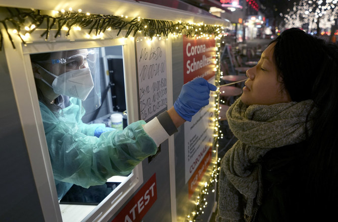 2021年12月21日、ドイツ、ベルリンのショッピング通りでコロナウイルス検査を実施する医療従事者（AP Photo/ミヒャエル・ゾーン）