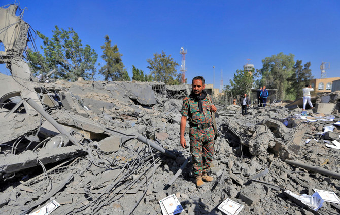 2021年12月21日、サヌアのフーシ派の武器庫を狙ったサウジ主導の連合軍による空爆後に、破壊された建物の瓦礫を確認するフーシ派民兵。（AFP通信）