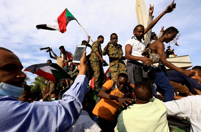 2021年12月19日、先月のスーダンのハルツームで起きたクーデター後に敷かれた軍政に抗議して大統領官邸にたどり着いたことに喜び、運用車両の上に乗る人々。(ロイター通信)