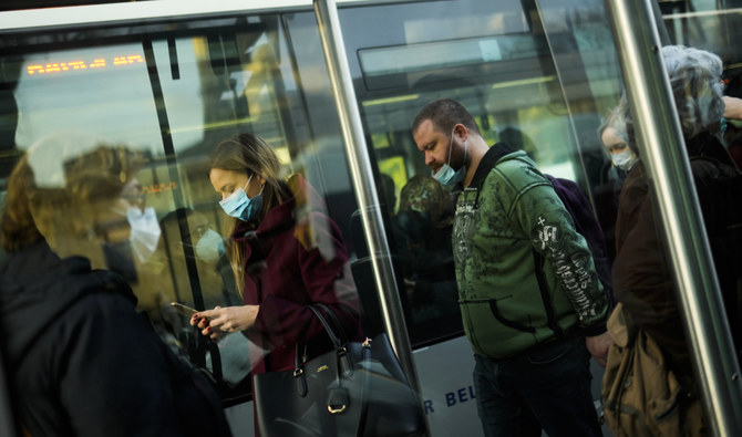 新型コロナの感染拡大防止のため、マスク姿で路面電車から降りる通勤者（2021年12月27日）。（AP）