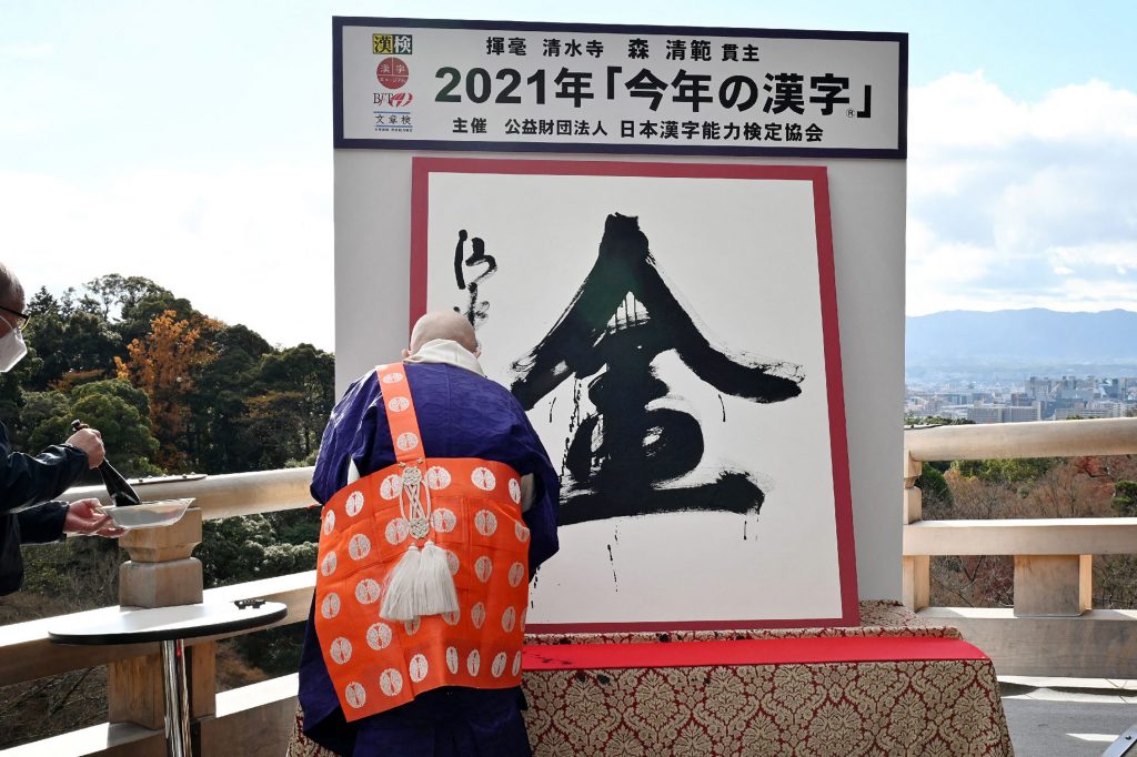 清水寺の森清範貫主が漢字の「金」を揮毫している。「金」は、2021年を最も良く象徴する漢字に選ばれた。2021年12月13日、京都市の清水寺にて撮影(写真提供:AFP通信)
