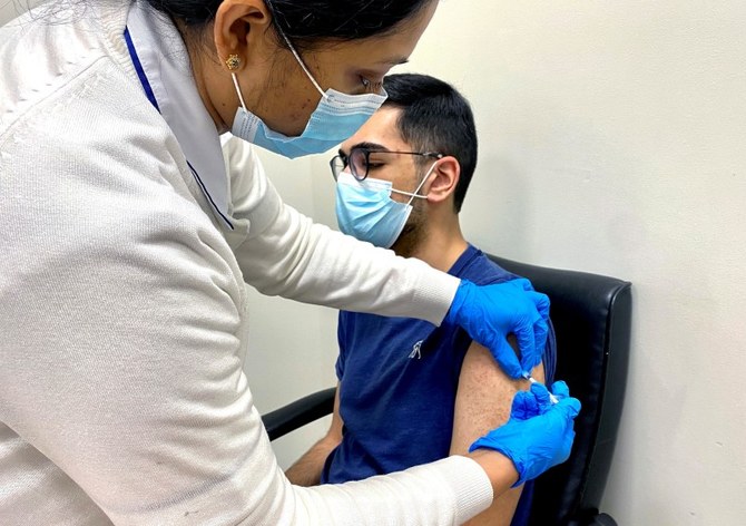 新型コロナウイルス感染症のワクチン接種を受ける男性（2020年12月28日、UAE、ドバイ）。（ロイター）