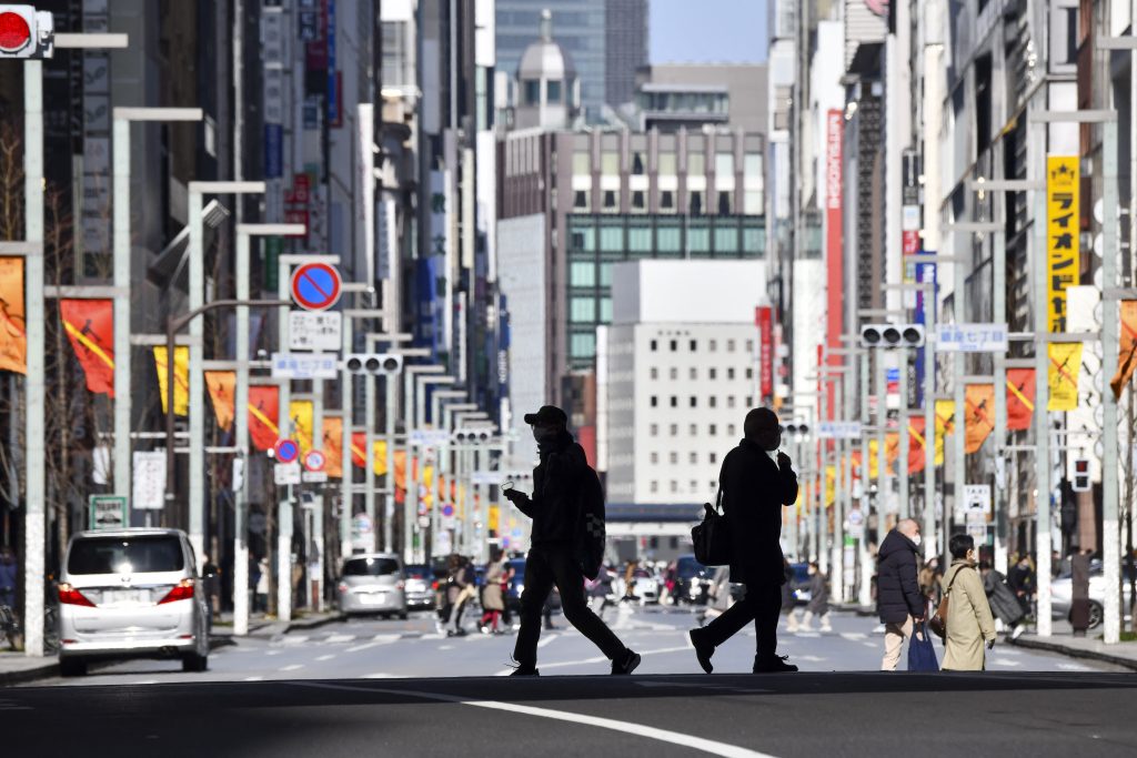東京の銀座商店街の通りを渡る歩行者。(AFP)