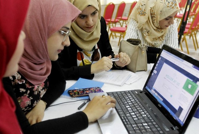 2018年11月17日、イラクの首都バグダッドにある起業家志望者向けのインキュベーター施設「The Station」でコンピューターをチェックするイラクの女性たち。（AFP）