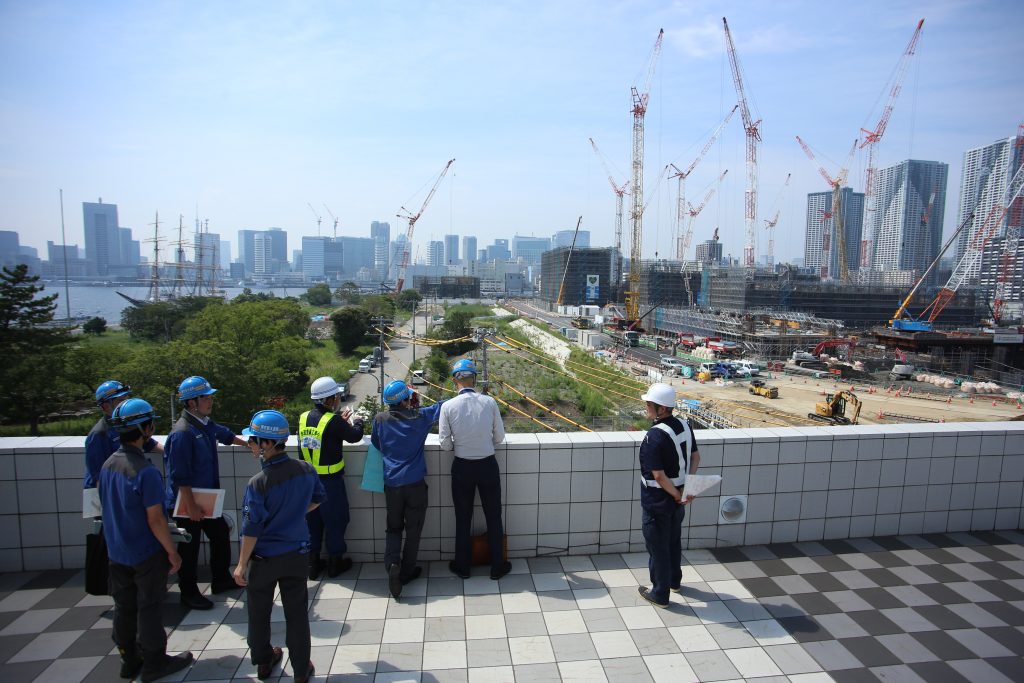 2018年、五輪選手村建設地を眺める関係者の写真。(ANJ/ピエール・ブーディエ)