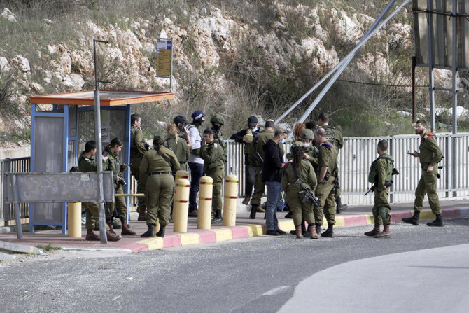 2021年12月31日、ヨルダン川西岸地区のギティ・アビシャール入植地近くの交差点で起きた刺傷未遂事件の現場となったバス停に集まるイスラエル軍兵士たち。(AP通信)